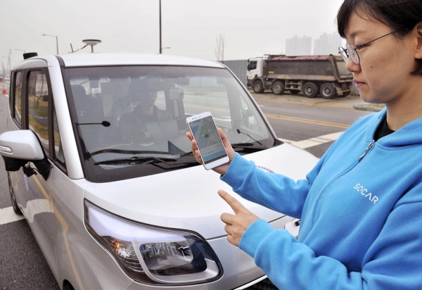 쏘카 관계자가 카셰어링용 자율주행차를 스마트폰으로 호출하고 있다.