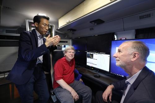 ETRI 이재영 박사가 지난 7일 제주 테크노파크 시연 차량 안에서 돌비(Dolby)와 삼성전자 관계자에게 방송·통신망 연동기술에 대해 설명하는 모습.