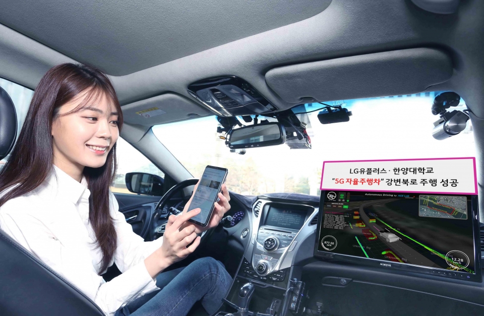 LG유플러스 모델이 5G 자율주행차 ‘A1’ 주행 중 휴대폰을 하고 있는 모습
