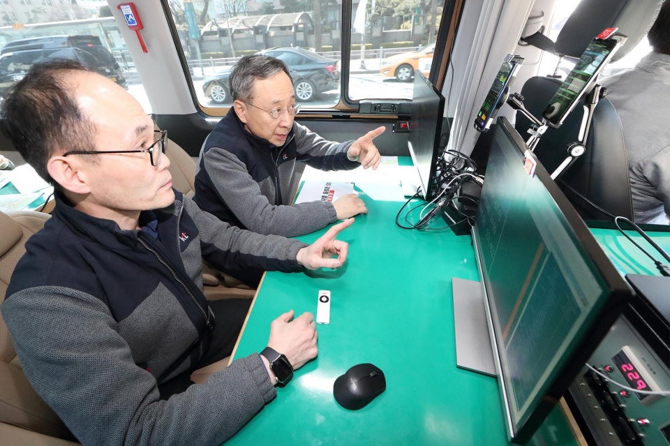 황창규 회장이 서울 광화문 일대에서 품질 측정 차량으로 이동하며, 5G 스마트폰으로 도로 환경에서의 품질 측정을 실시하고 있다.