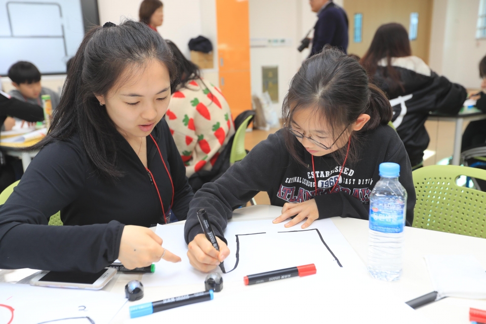 교동도에서 열린 KT글로벌멘토링 7기 결연식에 참석한 외국인 유학생과 초등학생 멘티가 오조봇 코딩 수업에 참여하고 있다.