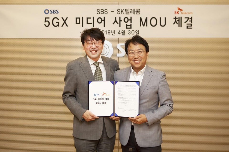 SK텔레콤 김혁 5GX 미디어사업그룹장(오른쪽)과 SBS 정승민 전략기획실장이 5G 기반 뉴미디어 사업 개발을 위한 MOU 체결 후 기념촬영하고 있다.