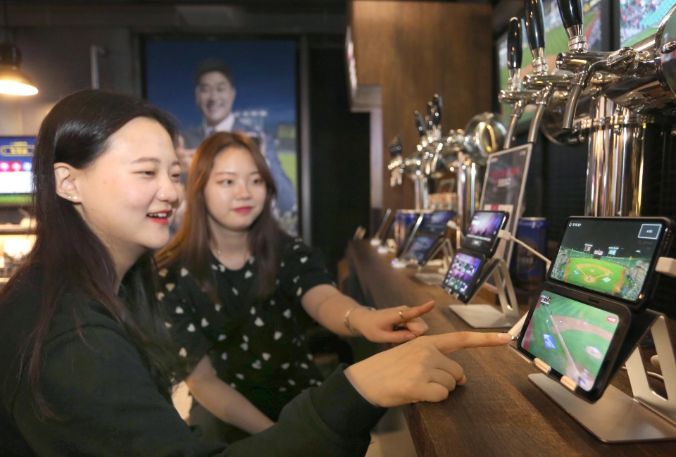 서울 강남 팝업스토어 ‘일상로 5G길’을 방문한 고객이 ‘V50 씽큐’ 듀얼스크린으로 U+5G 6대 서비스를 체험하고 있다.