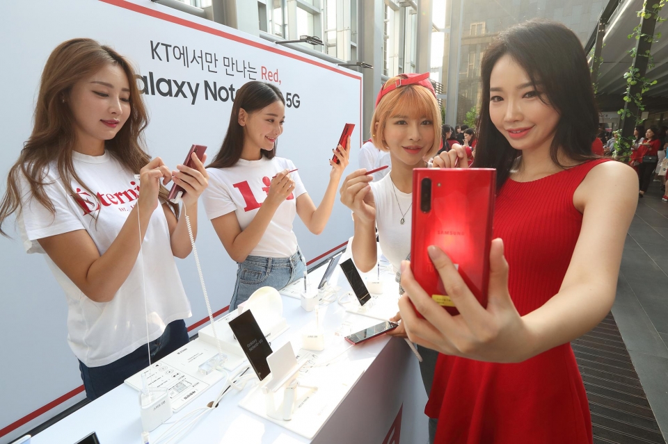‘갤럭시 노트10 5G’ 출시 기념 론칭 파티에서 모델들이 KT 전용 ‘아우라 레드’ 색상의 갤럭시 노트10 5G를 보고 있다.