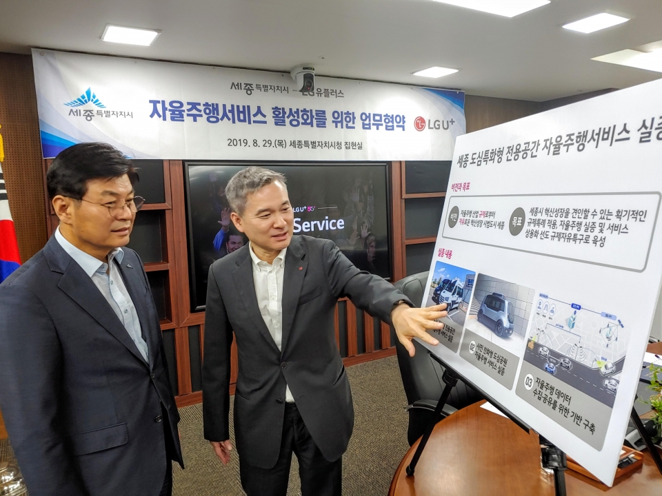 이춘희 세종시장(왼쪽)과 하현회 LG유플러스 부회장이 업무협약 후 5G 자율주행 셔틀 서비스 실증 계획을 살펴보고 있다.
