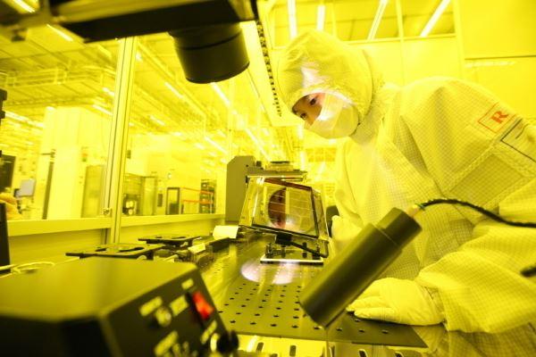 삼성전자 반도체 엔지니어가 작업에 앞서 회로가 새겨진 모습을 점검하고 있다.