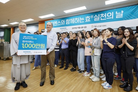 한국지멘스 더 나눔 봉사단이 서울 종로구 서울노인복지센터를 찾아 후원금 1000만원을 전달하고 있다.