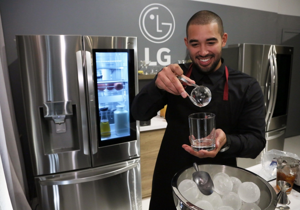 팝업 스토어의 칵테일 전문가가 LG 인스타뷰 냉장고에서 꺼낸 구형(球形) 얼음인 크래프트 아이스를 컵에 담고 있다.