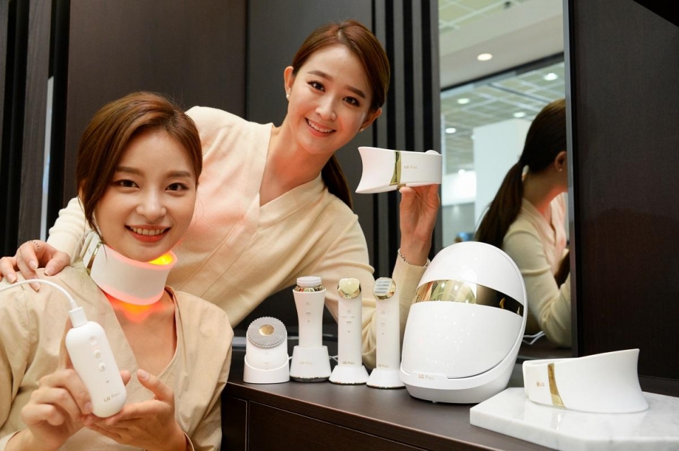 여성 모델들이 목 부위 피부 관리기기인 'LG 프라엘 더마 LED 넥케어' 제품을 소개하고 있다.