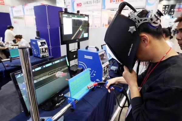'2019 첨단소재부품뿌리산업기술대전'이 열리고 있는 일산 킨텍스 제2전시장 한국생산기술연구원 VR체험관에서 한 관람객이 가상현실(VR)을 이용한 뿌리기술 용접체험을 시연하고 있다.