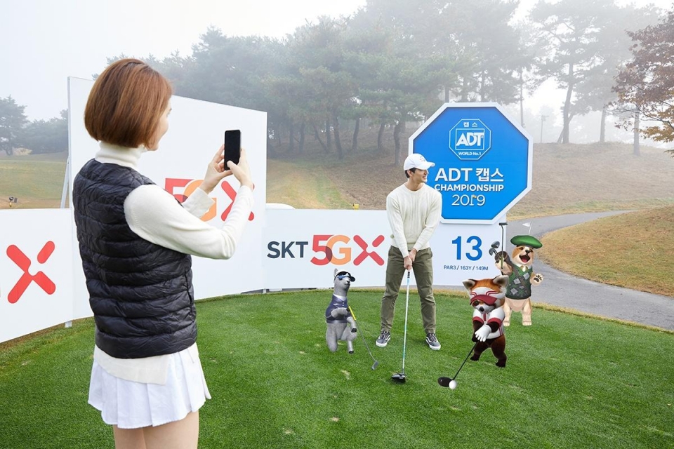 SK텔레콤 홍보 모델들이 천안 우정힐스CC의 ‘SKT 5GX 시그니처홀(13번 홀)’에서 ‘점프 AR 동물원 골프’로 AR 동물들과 사진을 찍는 모습.