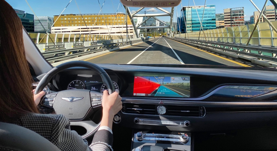 증강현실을 기반으로 주행경로 안내와 차로 이탈 경고 기능이 동시에 작동하고 있는 AR 내비게이션 콘셉트 이미지.