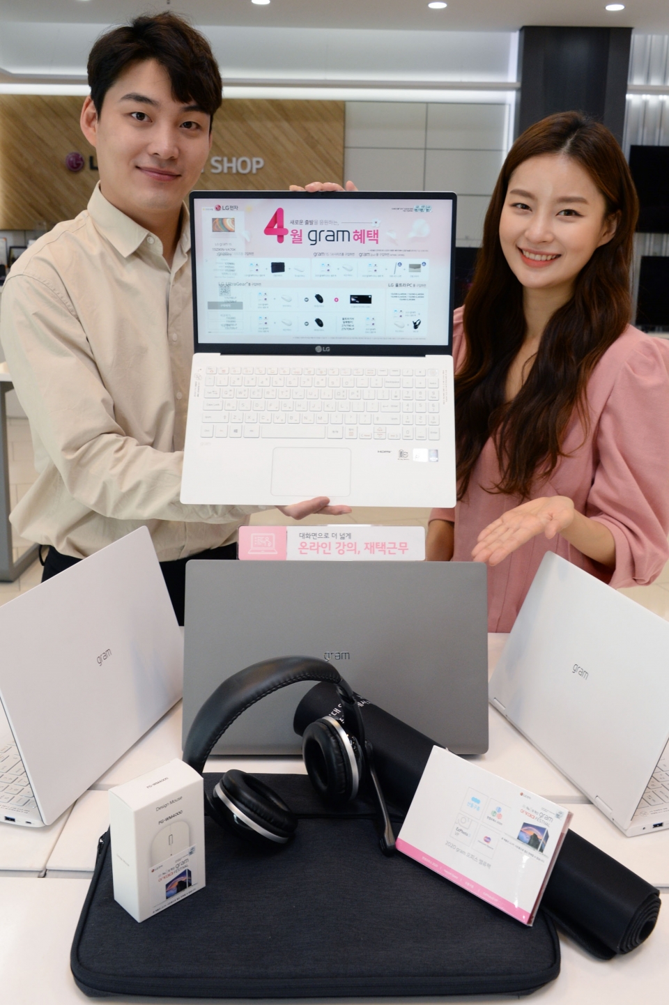 모델들이 LG전자 베스트샵 강남본점 내 노트북 판매코너에서 LG 그램 4월 구매 혜택을 소개하고 있다.