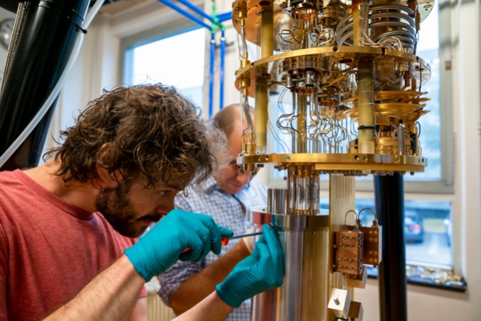 브라이언 타라 심 스키 (Brian Tarasimski)와 QuTech의 초전도 양자 회로 교수 레오나르도 디카를로 (Leonardo DiCarlo) 박사가 델프트 공과 대학 (Delft University of Technology)에서 양자 컴퓨팅을위한 희석 냉장고를 연구하고있다.