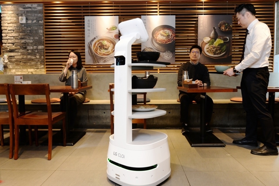 제일제면소 서울역사점에 방문한 고객들이 LG 클로이 서브봇을 체험하고 있다.