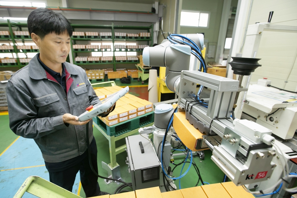 충북 제천에 있는 박원 공장에서 생산직 근로자가 KT 5G 스마트팩토리 코봇과 함께 작업하고 있다.
