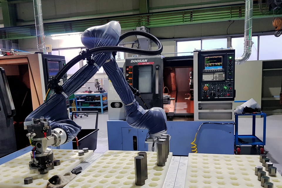 ㈜두산이 협력사 스마트공장 구축을 위해 도입한 협동로봇이 생산현장에서 작업을 수행하고 있다.